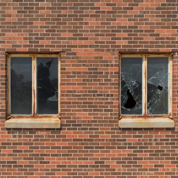 Smashed glass windows and brick wall