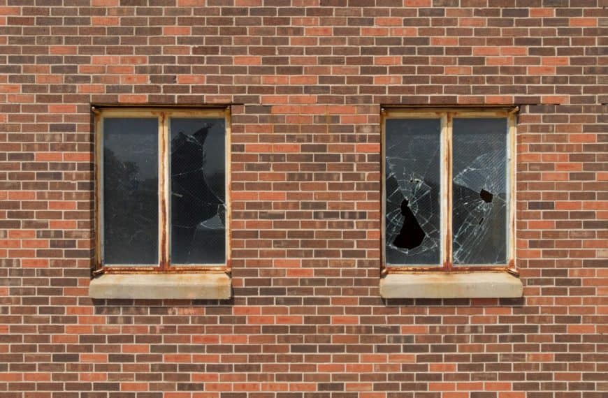 Smashed glass windows and brick wall